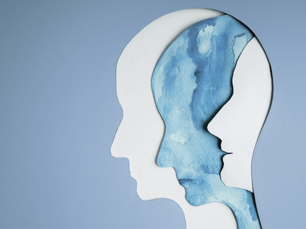 Two white human head figures are in-between a blue head figure. An artistic picture to represent multiple emotions.