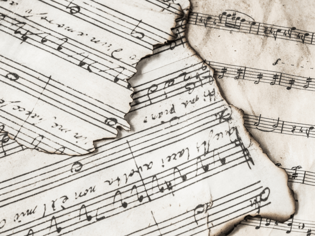 Old sheet music looks worn and damaged.